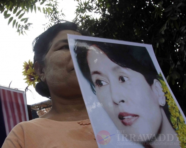 A woman hold a Aung San Suu Kyi’s portrait to welcome National League for Democracy leader Aung San Suu Kyi at the NLD headquarters in Rangoon, Burma.
