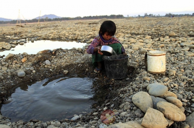A girl fetches water from a pool in a dry river in Myitkyina, Kachin State, about 1,600 km (1,000 miles) north of Rangoon, Burma.