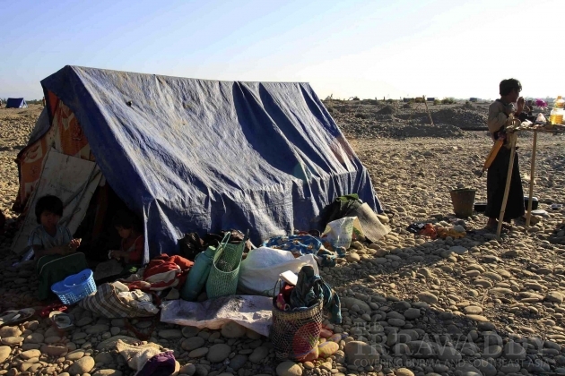 Children of Burma's Kachin national race sit in their make-shift tent as their family members pan for gold in a river in Myitkyina, Kachin State, about 1,600 km (1,000 miles) north of Rangoon, Burma.