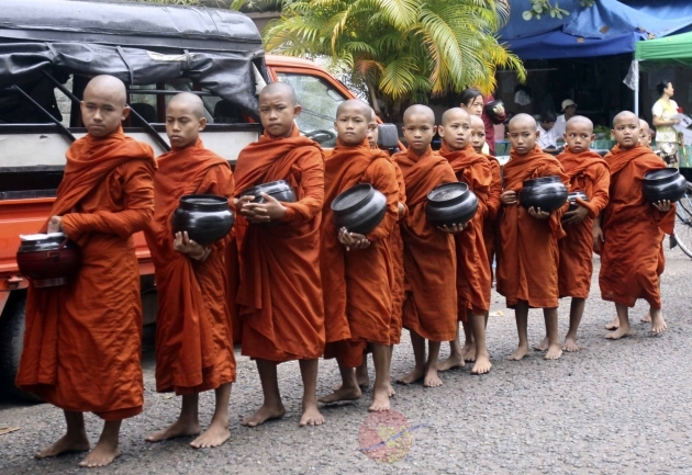 Novices walk through the road while asking for alms in Rangoon, Burma.