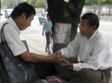 An astrologer reads palm on platform near Sule Pagoda in downtown, Rangoon, Burma.