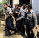 Burma policemen escort Ross Dunkley, founder of the English-Language Myanmar Times, as he leaves Kamayut township court after hearing in Rangoon, Burma. Dunkley has been held in Rangoon's Insein Prison since his Feb. 10 arrest for allegedly overstaying a visa.