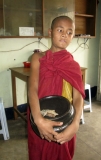 Young novice collecting alms at the coffee shop in Rangoon, Burma.
