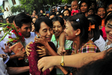 Myanmar democracy icon Aung San Suu Kyi receives a gift from local people during her visit to Nyaung Oo market along with her youngest son Kim Aris and her party members at Myanmar ancient historic city of Bagan Thursday, July.7, 2011, in Bagan, Myanmar