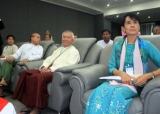 Myanmar democracy icon Aung San Suu Kyi, second left, arrives to attend the Conference on Green Economy and Green Growth at Myanmar Banks Association Hall in Yangon, Myanmar, Friday, Nov. 4, 2011. Others in the photo are unidentified.