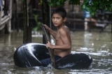 A boy playing by riding on life-buoy on 6th August as the houses from certain wards in Bago Region were floated due to the heavy rain and unusual tide.