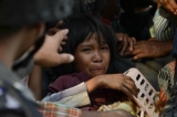 The following is the photos captured on March 22, 2013. The communal violence which broke out on March 20, 2013 left at least 40 people dead and forced hundreds from their homes following arson attacks. A girl terrified by the violence in Meiktila. (Photo - teza hlaing / The Irrawaddy)