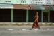 A Women walk in front of closed shops in the town centre of Maungdaw, after attacks on police posts over a week ago located Rakhine on Oct 17, 2016. (Hein Htet/The Irrawaddy)