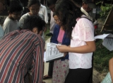 Voters search their names on a list to vote a local polling station in Rangoon, Burma.