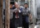 Burma policemen escort Ross Dunkley, founder of the English-Language Myanmar Times, as he leaves Kamayut township court after hearing in Rangoon, Burma. Dunkley has been held in Rangoon's Insein Prison since his February 10 arrest for allegedly overstaying a visa.
