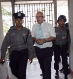 Burma policemen escort Ross Dunkley, founder of the English-Language Myanmar Times, as he leaves Kamayut township court after hearing in Rangoon, Burma.