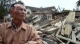 A injure man  walks past the collapsed building in Tarlay, Easter Shan State, Burma.