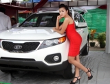 06-09-12 luxury car show - PHOTO - Khin Maung Win A model poses with cars displayed at ' The Most Amazing Exhibition and Car Show 2012 ' at Myanmar Convention Centre (MCC) in Yangon, Myanmar.