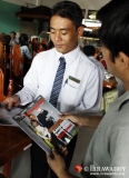 22-12-12 - Irrawaddy mag - PHOTO - Jpaing Tourists with a copy of the first Irrawaddy Magazine in Rangoon