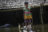 Children's stand in front of her house on a flooded water in Hlegu at the Yangon region of Myanmar.
