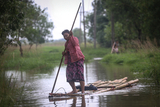 Woman  paddles a makeshift bamboo raft on a flooded water in Hlegu at the Yangon region of Myanmar.