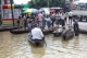 local residents on a boat through a flooded road after the Bago River swollen in Bago.