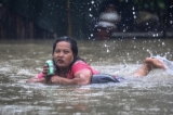 A Woman drinking Heineken while riding on the life-buoy on 6th August despite of houses drowned in certain wards from Bago Region due to the heavy rain and unusual tide.