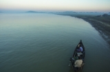 two fishermen coaxing an Irrawaddy dolphin to go fishing with them at dawn. (Photo -teza hlaing/ The Irrawaddy)